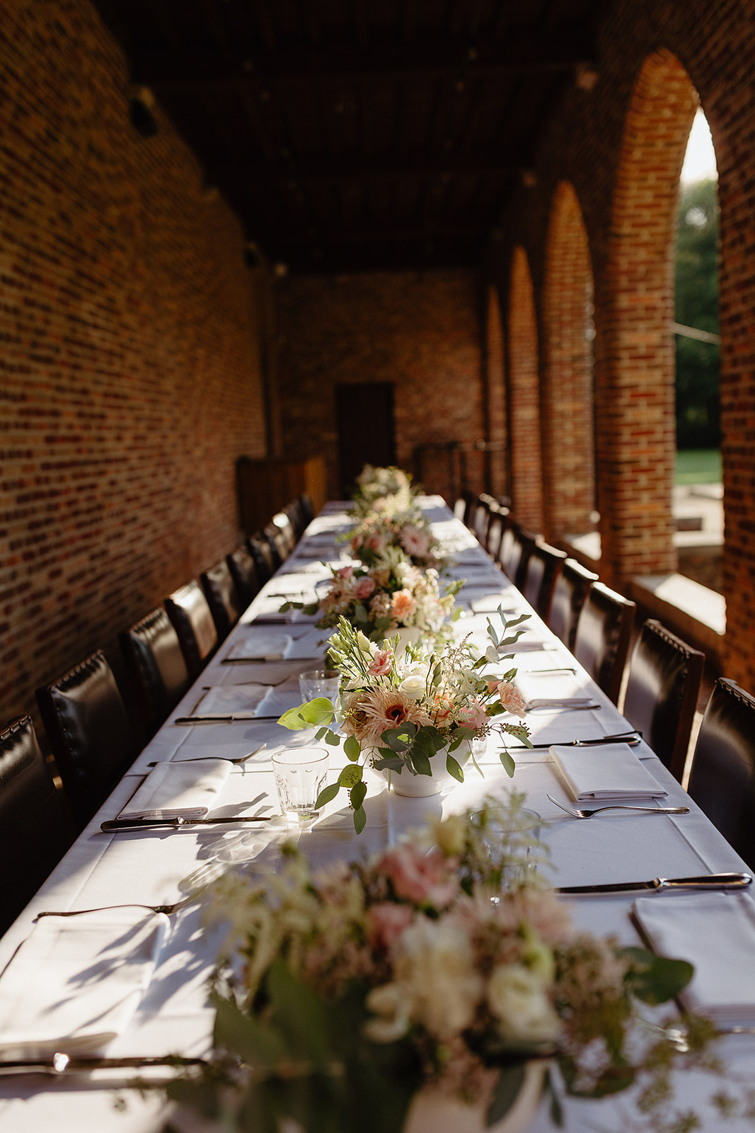 Long party table in the arcade with flowers