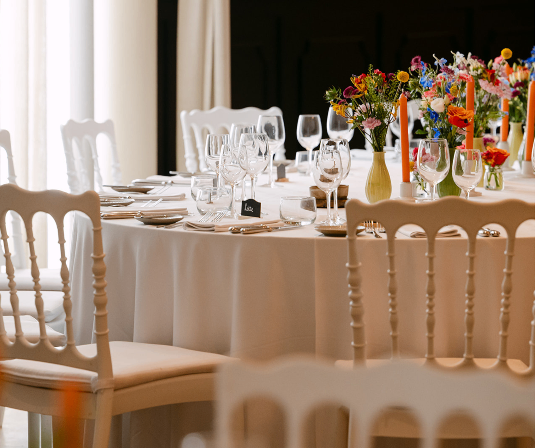 Festively decorated round table with colorful flowers and candles at Corsendonk Hooge Heyde