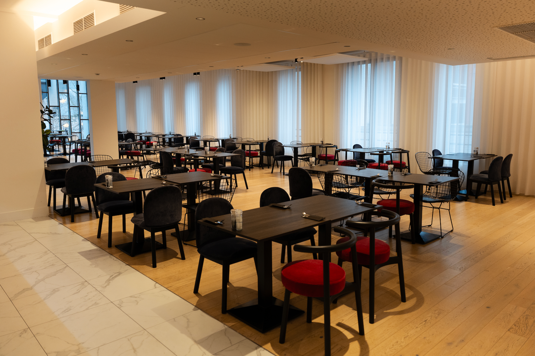 Lichte ontbijtzaal met zwarte tafels en velours stoelen bij Corsendonk Turnova