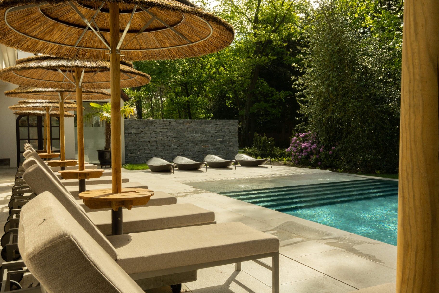 Outdoor swimming pool with parasols at Wellness Namasté