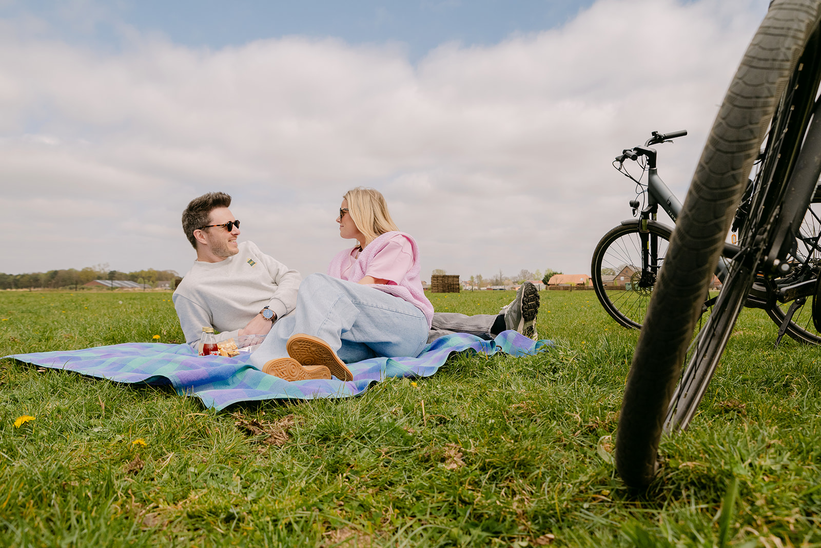 Couple picnics in a Kempen meadow during a bike ride