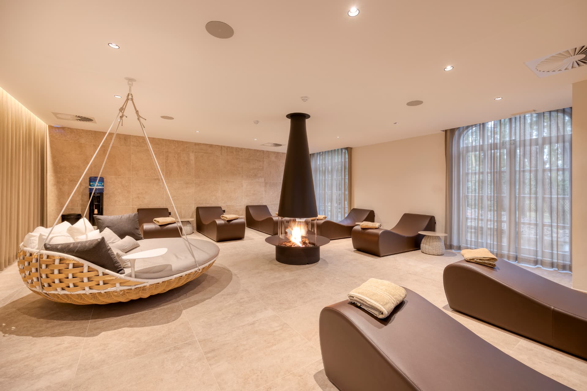Relaxatieruimte met open haard, ligbedden en hangbank