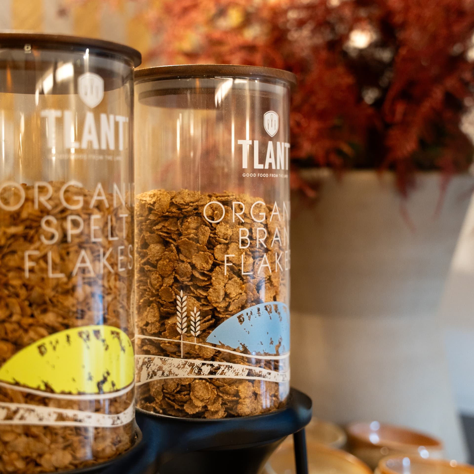 Glazen dispensers met biologische spelt- en zemelenvlokken op het ontbijtbuffet