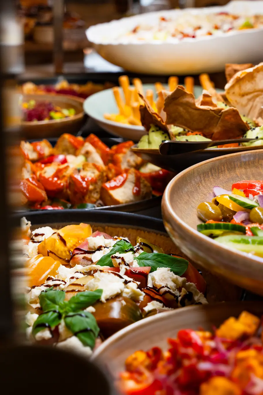 Buffet met kleurrijke salades, tomaat-mozzarella en warme gerechten tijdens de brunch
