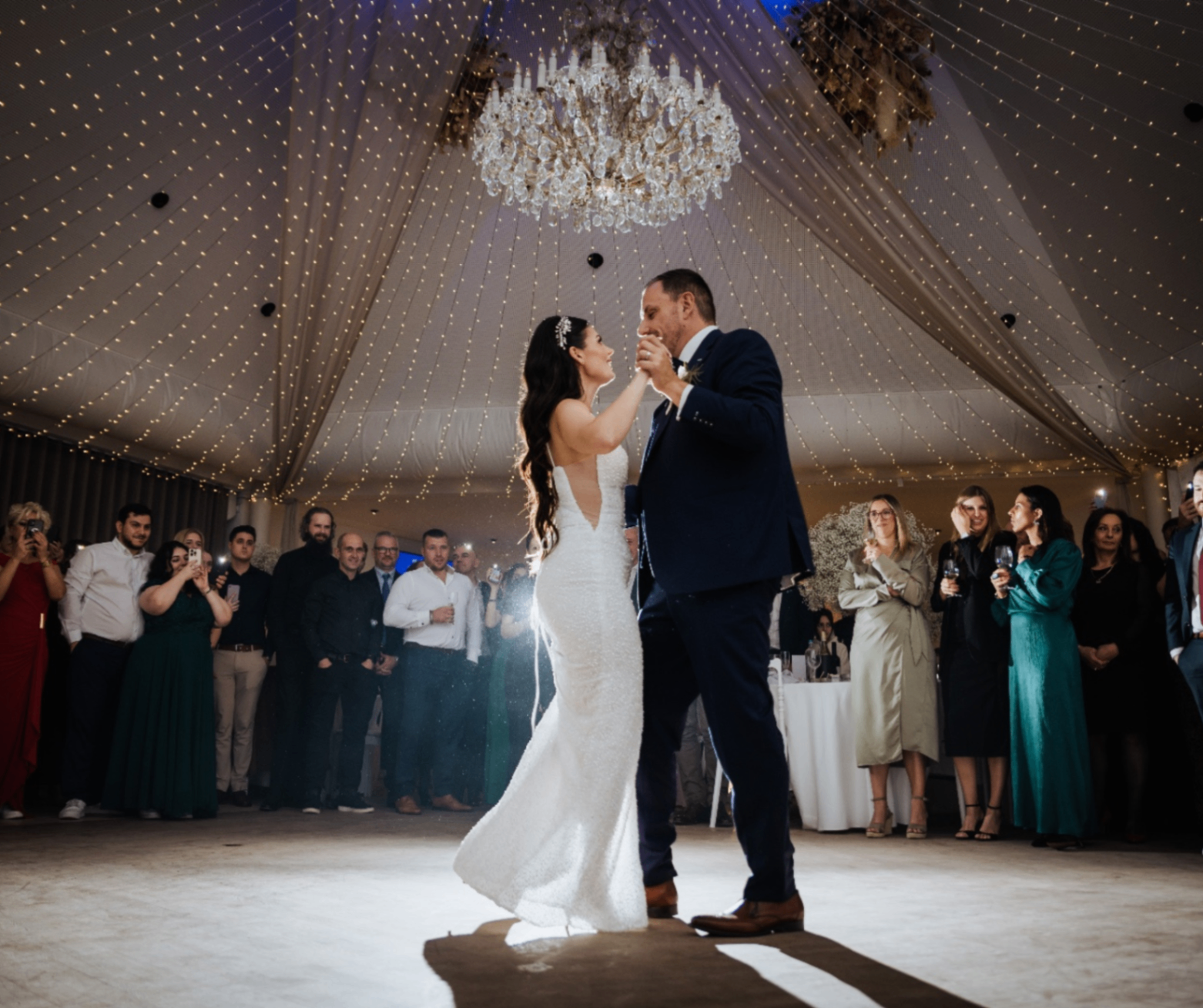 Bride and groom during their opening dance under the chandelier in the Corsendonk Hooge Heyde banquet hall