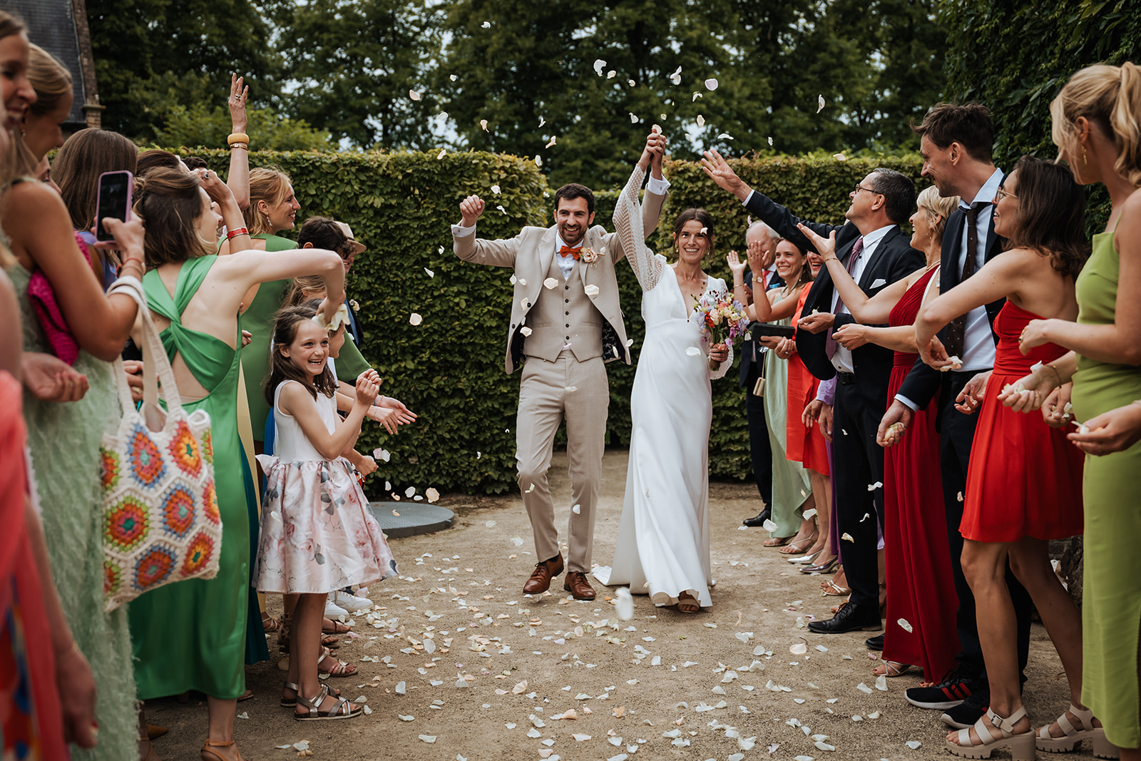 Bridal couple walks through a rain of flower petals