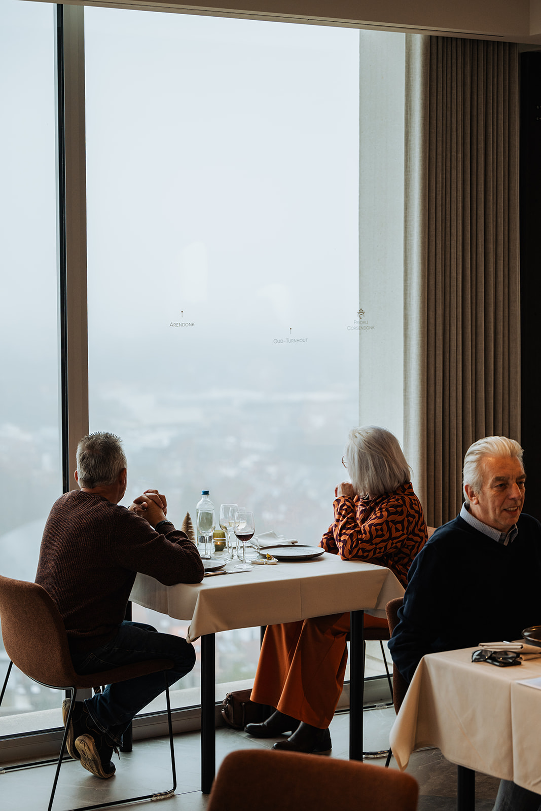 Gasten aan tafel bij het panoramaraam met zicht over Turnhout