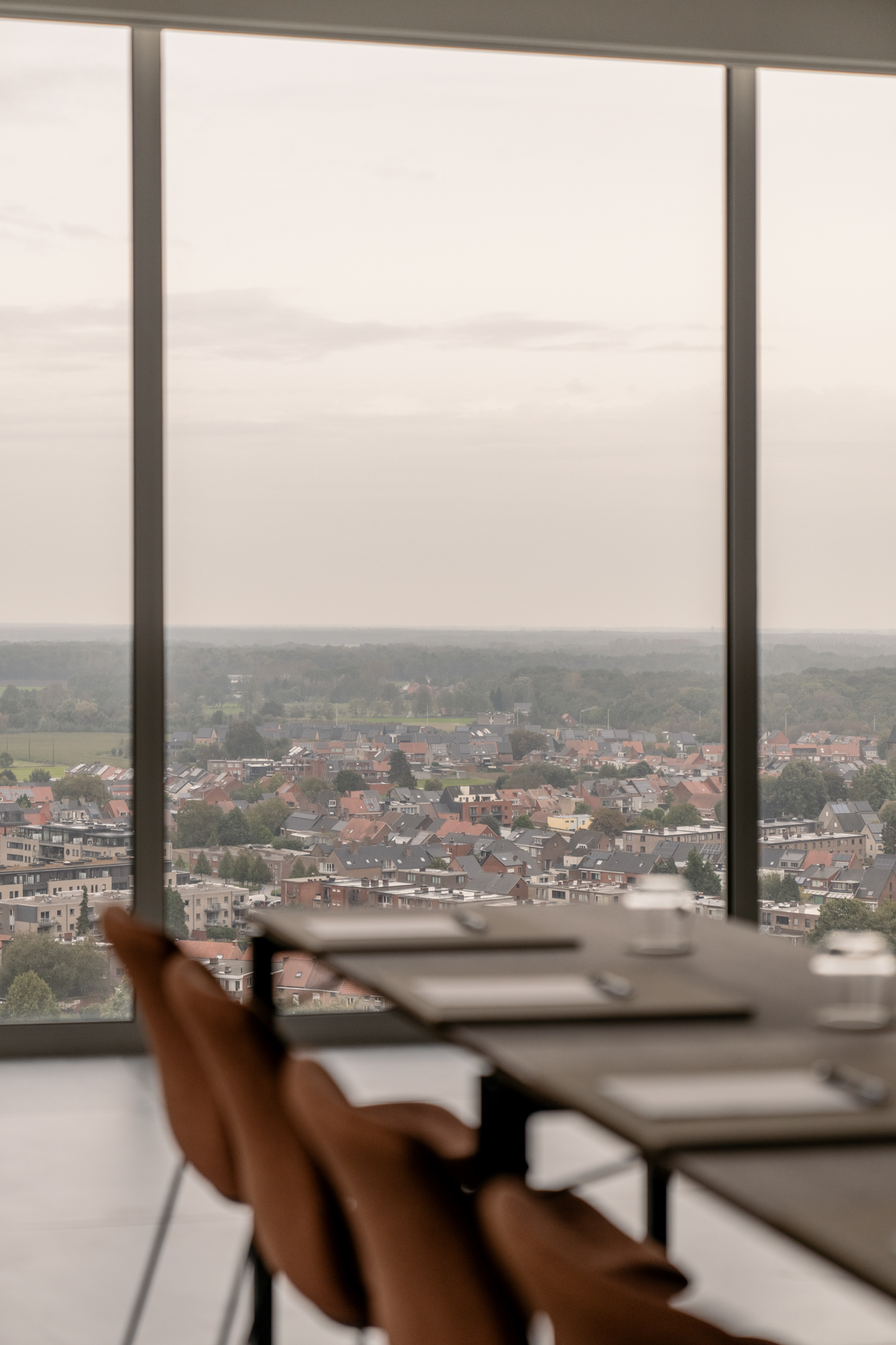 Vergadertafel aan het panoramaraam met zicht over Turnhout bij Sky Venue