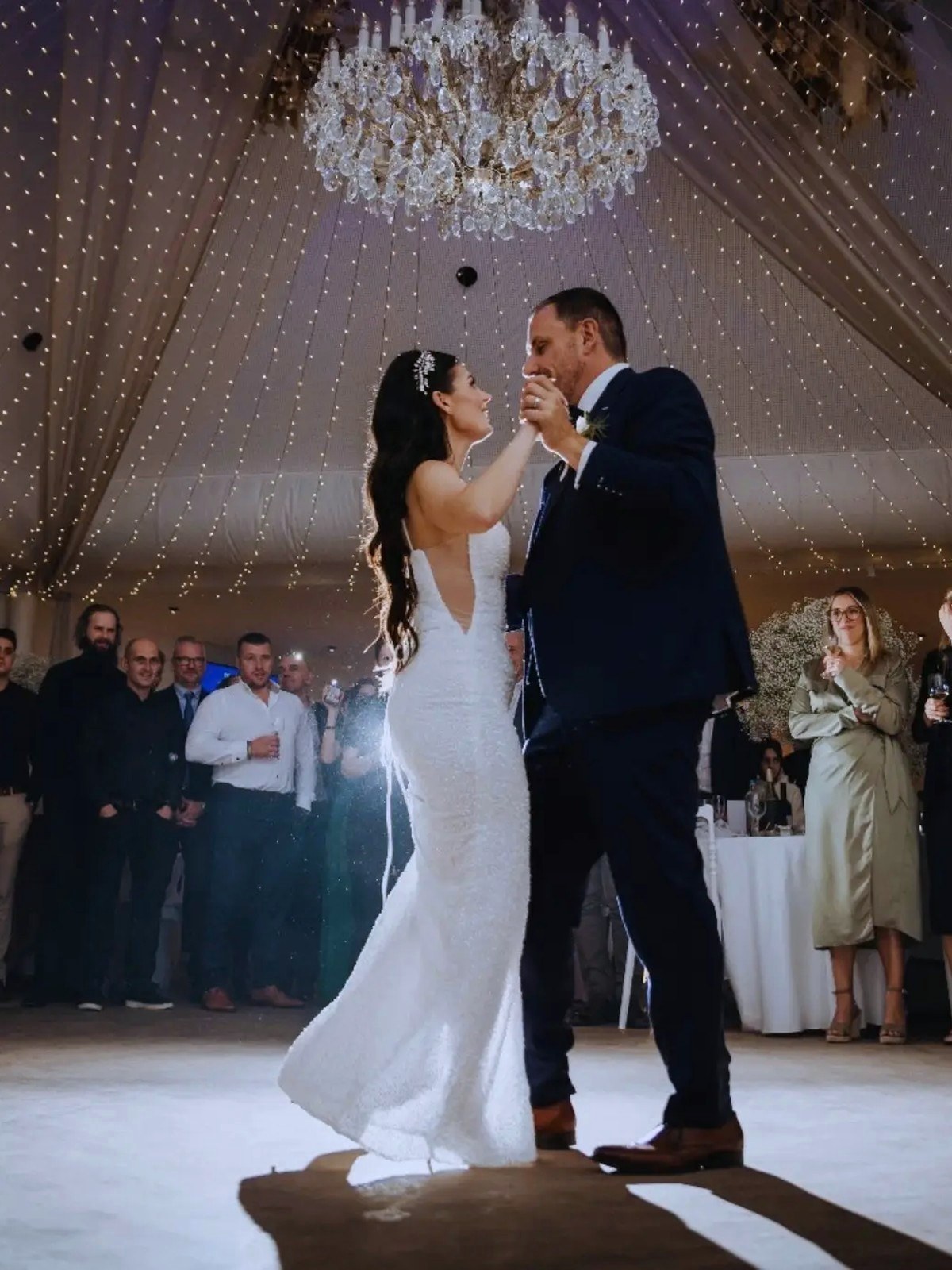 Bride and groom during their opening dance under the chandelier in the Corsendonk Hooge Heyde banquet hall