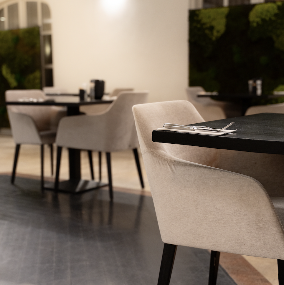 Sfeervolle ontbijtzaal met beige fauteuils en gedekte tafels bij Hooge Heyde