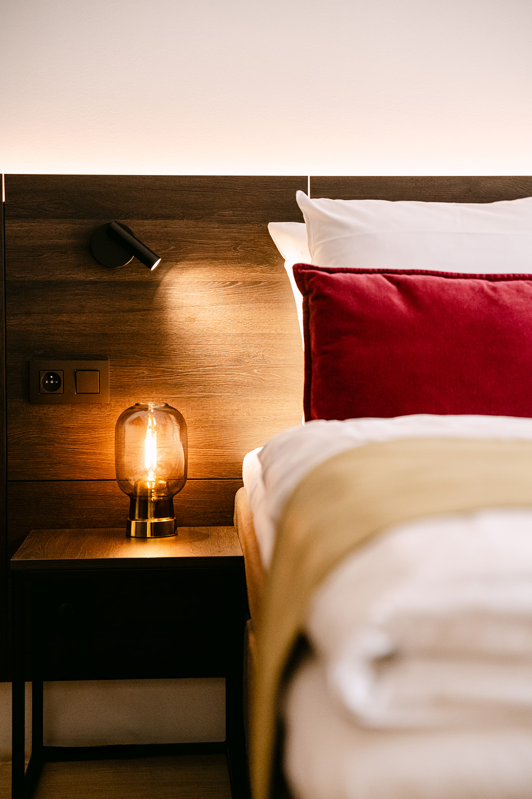 Sfeervol verlicht nachtkastje met leeslamp in een hotelkamer van Corsendonk Turnova