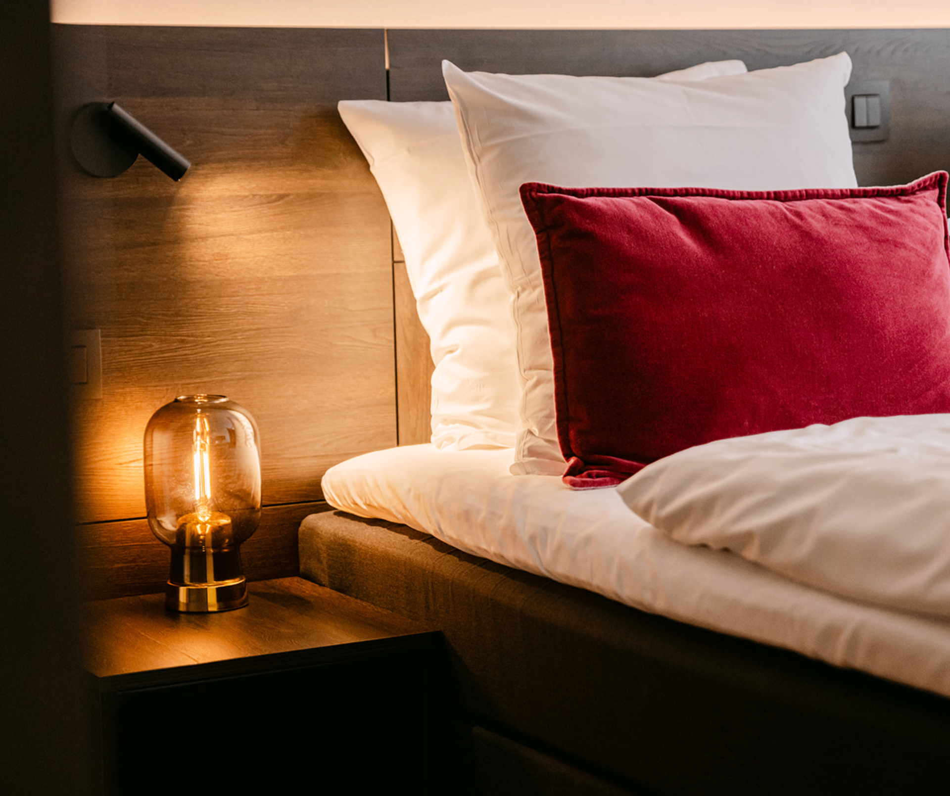 Atmospheric hotel room with warm night light and velvet pillow at Corsendonk Turnova